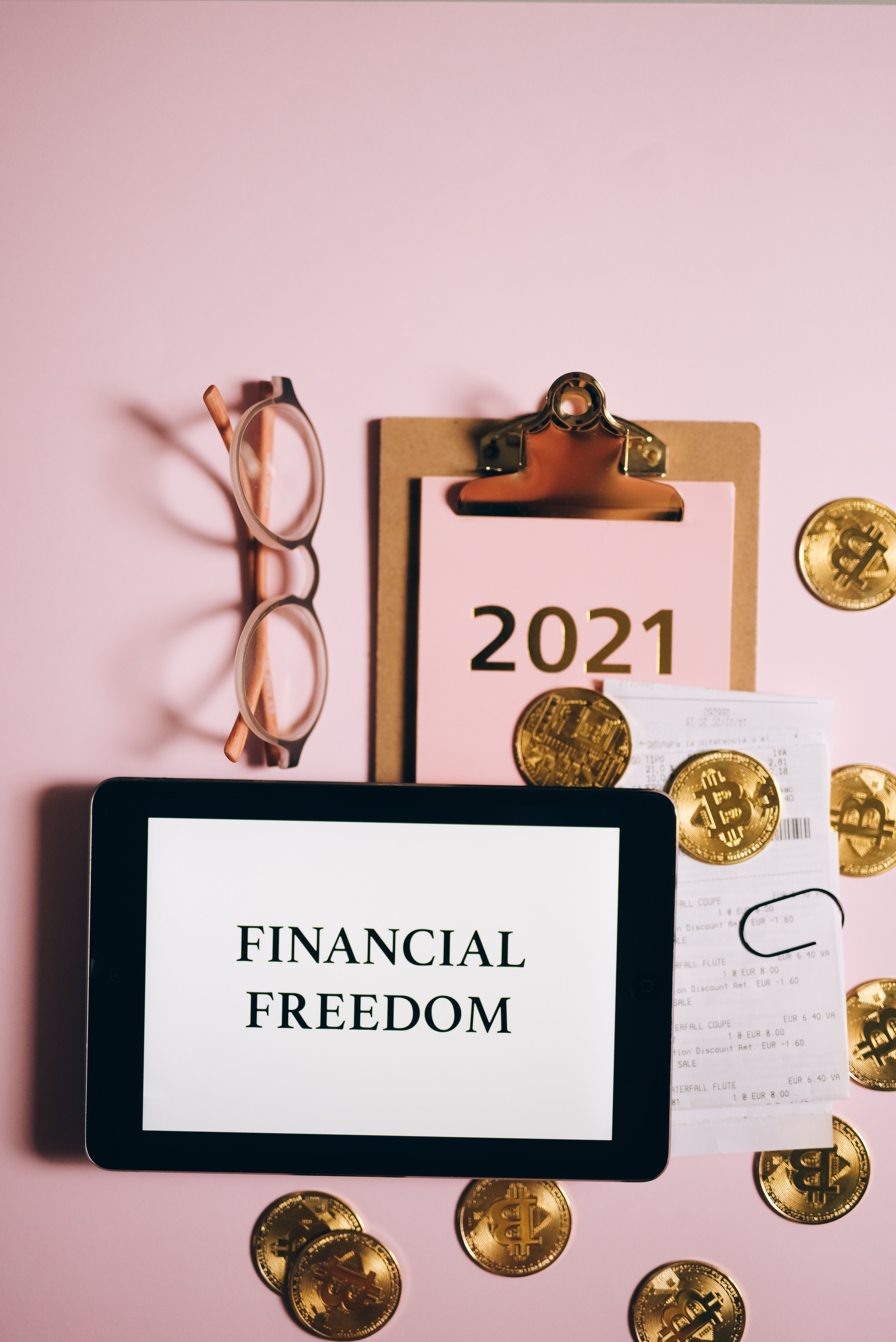 Tablet displaying Financial Freedom with savings and investment materials nearby